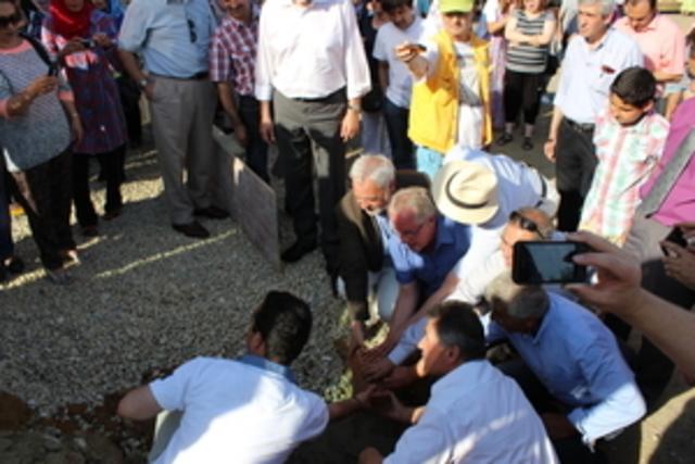Der Symbolstein wird mit vereinten Kräften in den Beton versenkt