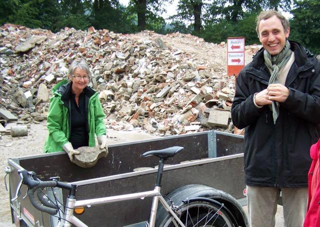13.09.2013: InterKulturGarten Pfaffenhofen an der Ilm: Material- und Glückstag: Die Firmengruppe Hechinger spendet uns großzügig für Wegebau und Terrassierung der ersten Parzellenfläche Recycling-Asphaltbruch und Steine aus seiner Deponie. Maximilian Hechinger und Brigitte Beckenbauer beim Steineauflegen.