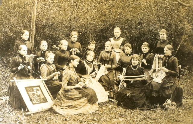 Näherinnen gehen im Freien ihrer Tätigkeit nach (um 1900).