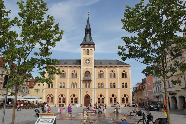 Der Hauptplatz vor und nach der Umgestaltung: wo zuvor Verkehr dominiert hat, spielen jetzt Kinder und laden Straßencafés zum Verweilen ein.