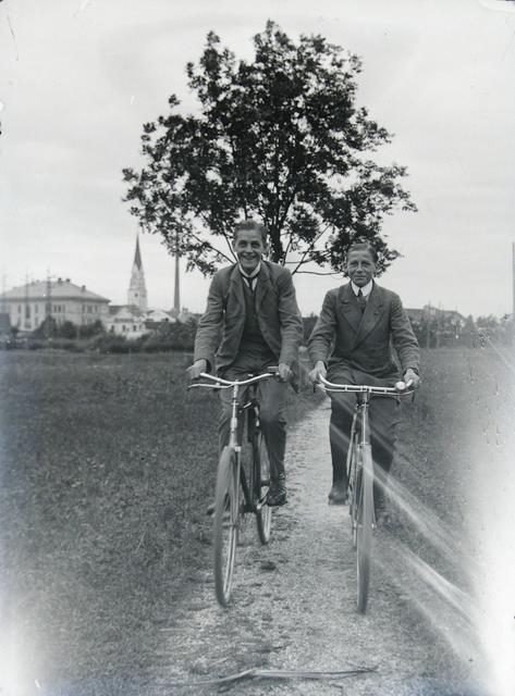 Ein altes Foto aus dem Stadtarchiv: 2 Radfahrer vor der Stadtsilhouette.