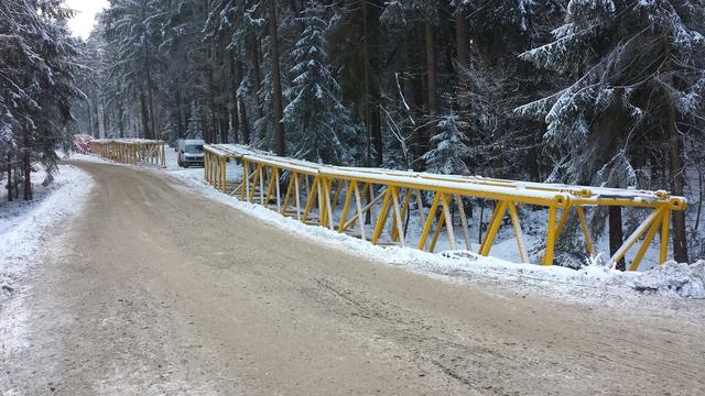 Der große gelbe Baukran liegt noch nicht zusammengebaut im Schnee