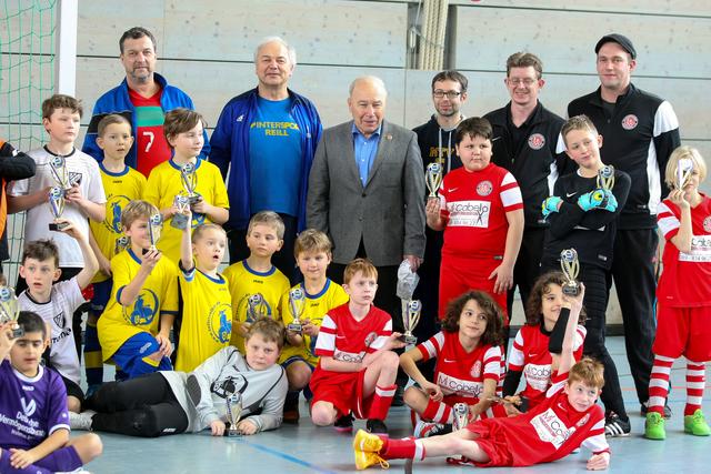 Die E3 des MTV Pfaffenhofen (in gelb) und das Team vom TSV Gilching (in rot). Im Hintergrund die MTV Trainer Alex Schlager und Helmut Reiter, Kult-Trainer Karsten Wettberg, MTV Jugendleiter Tom Wilhelm und das Trainerteam aus Gilching.