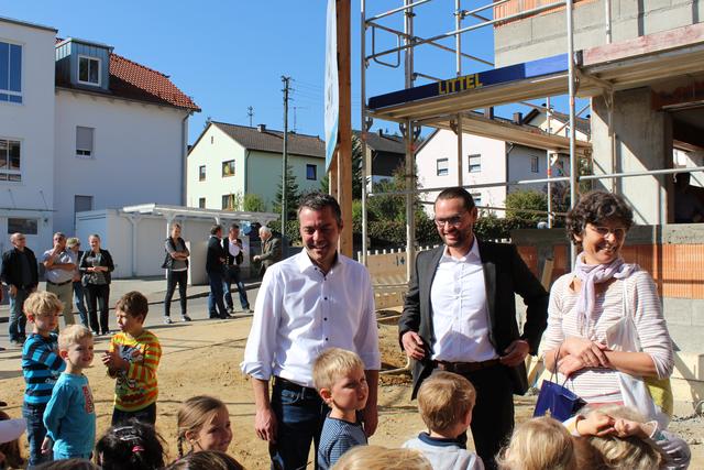 Bürgermeister Thomas Herker und WBG-Geschäftsführer Frank Dunkel mit Besuchern des Richtfests an der Ziegelstraße und Kindern der Kita St. Andreas.