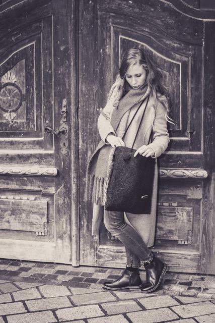 Kleiderkammer Mitglied Angelina Beck mit einer RestCycling-Tragetasche aus einer ehemaligen Filzjacke