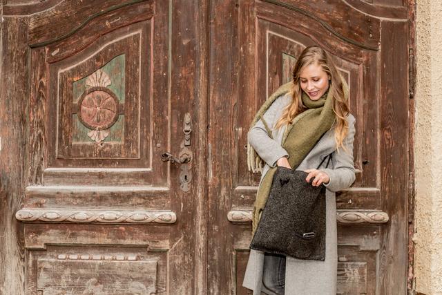 Kleiderkammer Mitglied Angelina Beck mit einer RestCycling-Tragetasche aus einer ehemaligen Filzjacke