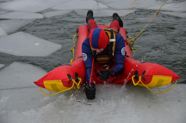 Wasserretter trainiert die Fortbewegung es Eisrettungsschlittens mit Hilfe von Eispickeln. Es zeigt sich, dass dies äußerst anstrengend ist. Das Bild entstand bei einer Übung im Freibad. | Foto: Wasserwacht