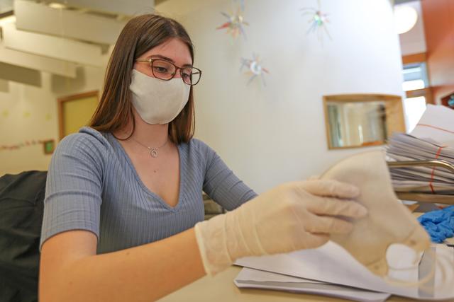 Mitarbeiterin einer städtischen Kita beim Konfektionieren der Masken