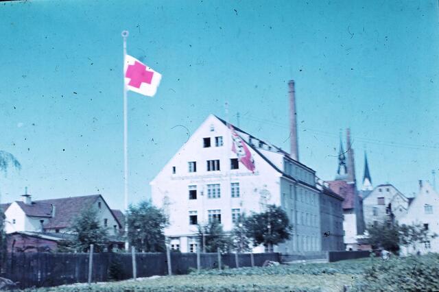 Um die Lazarette vor Fliegerangriffen zu schützen, ließ man in den letzten Kriegstagen, wie hier beim Arbeitsdienstgebäude am Stadtgraben, die Rot-Kreuz-Flagge hissen (1945).