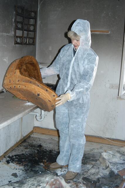 Auch das noch: Der nächtliche Brand im ersten Stockwerk machte diesen gänzlich unbewohnbar. Feuerwehrler löschten den Brand und verabreichten den Vierbeinern einzeln und nacheinander immer wieder Sauerstoff gegen die Dämpfe. Im Schutzanzug sucht die damalige Vereinsvorsitzende Kostinek nach Dingen, die eventuell noch brauchbar sind. | Foto: Pfaffenhofener Kurier