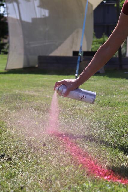 Auf der Wiese vor der Bühne werden die Bereiche für die Picknickdecken markiert. 
