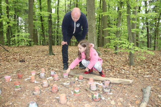 Ein Kind zeigt ihrem Vater ihr Insektenhotel.