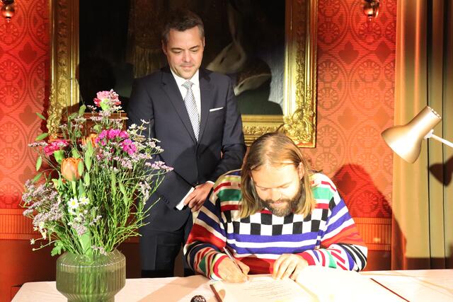 Matthias Wurm trägt sich in das Goldene Buch der Stadt ein. 