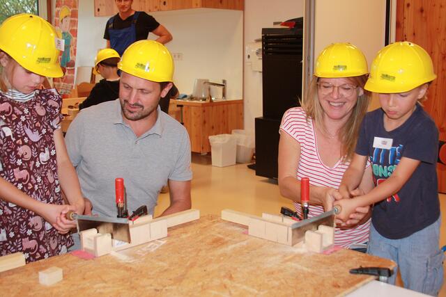 Andreas Kufer, Geschäftsführender Gesellschafter der Firma Hechinger und Angelika Wald, Leiterin der Kita Ecolino halfen den Kindern beim Sägen. 