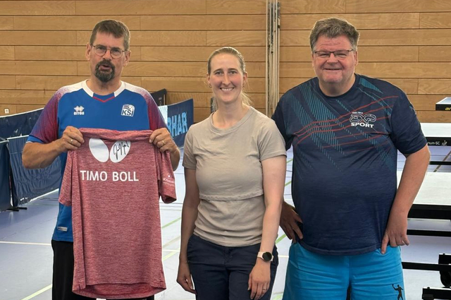 Karl Heigl ist der glückliche Gewinner des Timo Boll-Trikots. In der Mitte Losfee Anja Boerma, rechts Jochen Maurer