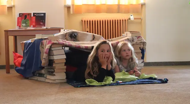 So lässt es sich aushalten: Die Kinder lauschen in ihrer selbstgebauten Bücherhöhle der spannenden Geschichte | Foto: M. Brendel