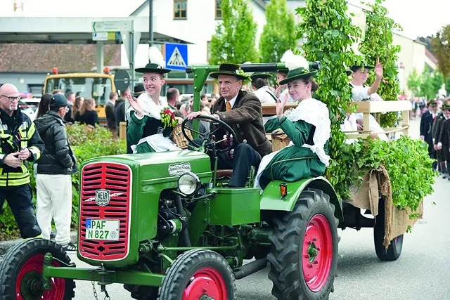 Historischer Bulldog mit Hopfenwagen und Trachtlern beim Volksfestauszug in Pfaffenhofen. | Foto: Gebirgs- und Volkstrachtenverein Ilmtaler Pfaffenhofen e. V.