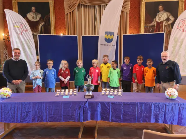 Gruppenauslosung zum KiGa-Cup 2025 mit Bürgermeister Thomas Herker (links) und Fördervereins-Vorstandsmitglied Robert Schröder sowie je 1 Kind jeder Kita im Trikot der Kita-Farbe