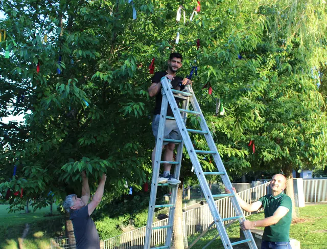 Sie haben den Baum der Religionen mit bunten Bändern geschmückt (von links): Shemsi und Hajdin Haziri sowie Ardian Ndreka.  | Foto: E. Steinbüchler