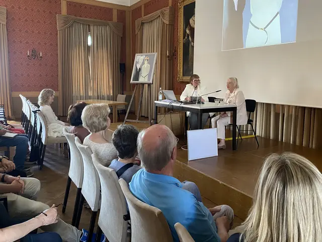 Publikum im Festsaal, auf der Bühne Karin Probst mit Bürgerin und einem Kunstwerk