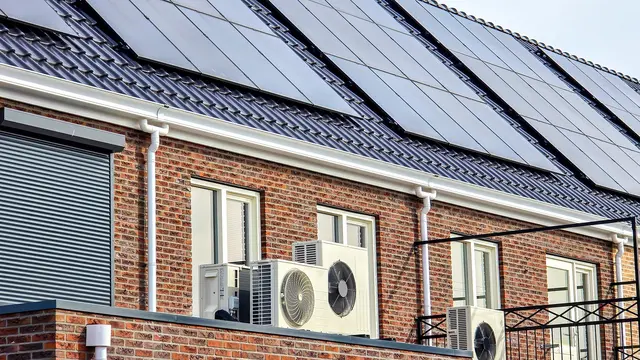 Reihenhäuser mit jeweils PV auf dem Dach und einer Wärmepumpe davor